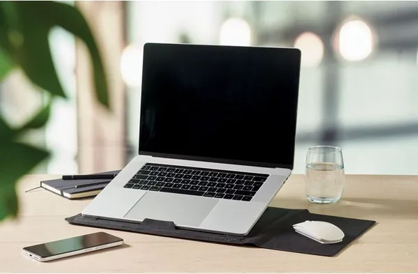 Opvouwbare laptop stand met sleeve en muismat op een bureau
